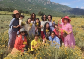 Isabelle dans un champs d'immortelles avec ses clients japonais en Corse